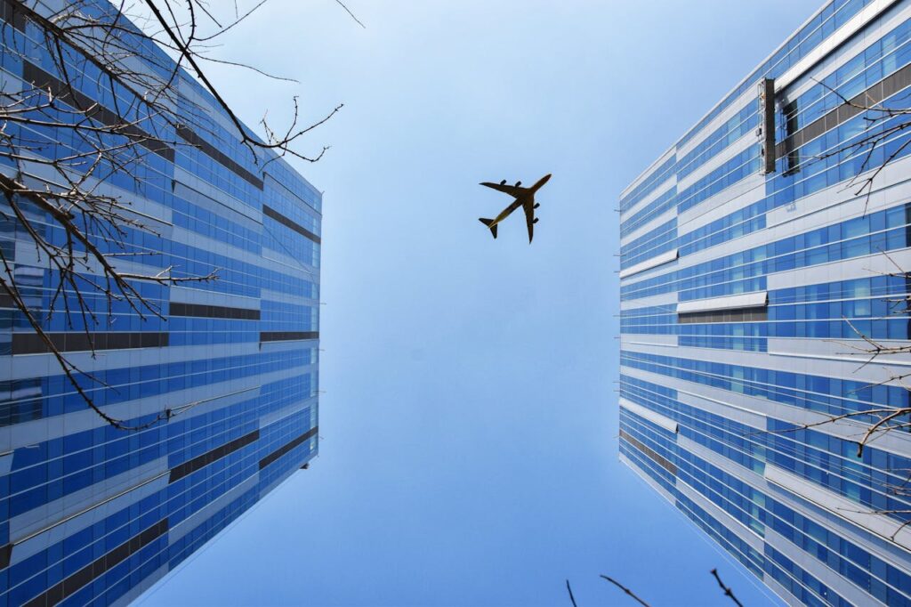 Airplane Near Blue and Grey Building